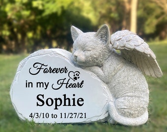 May include: White ceramic memorial stone with a sleeping cat with wings. The stone has the text "Forever in my Heart Sophie 4/3/10 to 11/27/21" on it.