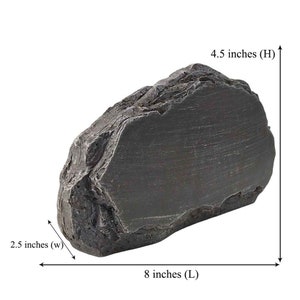 K&ouml;nnte beinhalten: Ein gro&szlig;er, dunkelgrauer, unregelm&auml;&szlig;ig geformter Stein mit einer rauen, strukturierten Oberfl&auml;che. Der Stein ist 20,3 cm lang, 11,4 cm hoch und 6,4 cm breit.