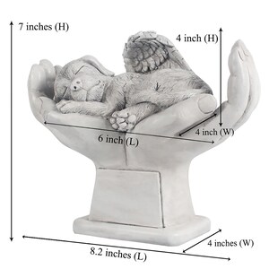 May include: White ceramic memorial sculpture of a sleeping dog with angel wings resting in cupped hands. The sculpture is 7 inches tall, 8.2 inches long, and 4 inches wide.