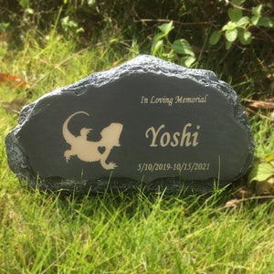 K&ouml;nnte beinhalten: Ein grauer Steindenkmal mit einer Eidechsen-Silhouette und der Inschrift "In Loving Memorial Yoshi 5/10/2019-10/15/2021".