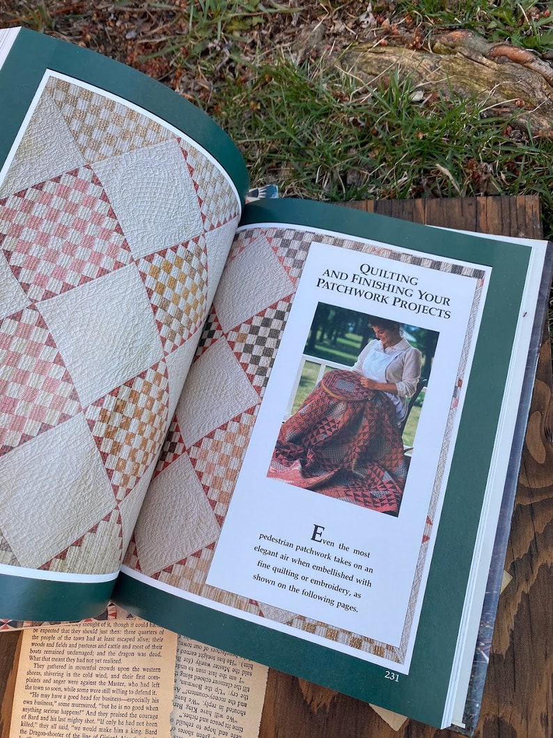 Pode incluir: Um livro aberto em uma p&aacute;gina sobre quilting e acabamento de projetos de patchwork. A p&aacute;gina apresenta uma foto de uma mulher acolchoando um edredom de patchwork com uma variedade de cores e padr&otilde;es. O texto na p&aacute;gina diz "Mesmo o patchwork mais simples adquire um ar elegante quando embelezado com quilting ou bordado finos, como mostrado nas p&aacute;ginas seguintes."