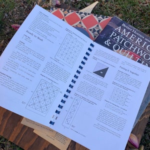 Pode incluir: Um close-up de um livro intitulado "Better Homes and American Patchwork & Quilting" com uma p&aacute;gina aberta em uma se&ccedil;&atilde;o sobre "Colocando tudo junto". A p&aacute;gina apresenta diagramas e instru&ccedil;&otilde;es para montar um bloco de colcha.