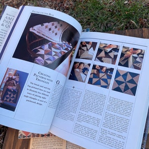 Pode incluir: Um livro aberto em uma p&aacute;gina sobre a cria&ccedil;&atilde;o de padr&otilde;es com tri&acirc;ngulos em patchwork. A p&aacute;gina apresenta uma foto de um banco com uma colcha feita de tri&acirc;ngulos azuis, marrons e brancos. O texto da p&aacute;gina explica como juntar os tri&acirc;ngulos para criar um design de patchwork.