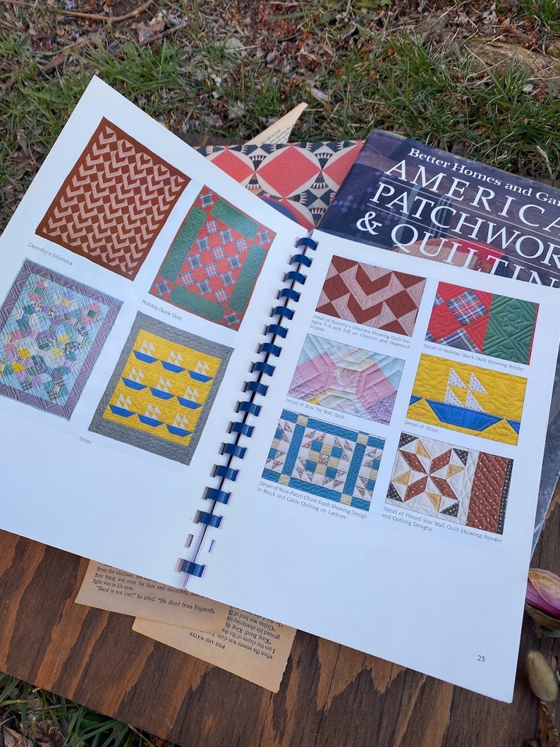 Pode incluir: Um livro intitulado "America Patchwork & Quilting" de Better Homes and Gardens. O livro apresenta uma variedade de designs de colchas, incluindo "Dorothy's Dilemma", "Holiday Chick Quilt", "Row the Kel Quilt", "Detalhe do "Inch Charm Dash" mostrando o design em blocos e acolchoado de cabo em treli&ccedil;as", "Detalhe do acolchoado de parede de estrela pin&ccedil;ada mostrando a borda e os designs de acolchoado", e "Detalhe do "Holiday Chick Quilt" mostrando quadrados pin&ccedil;ados e formas de chevron e diamante "Fat"".