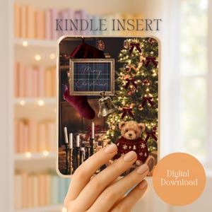 May include: A festive Kindle Insert design with a Christmas theme. The image shows a decorated Christmas tree, a teddy bear in a sweater, a framed plaid design with "Merry Christmas" text, and a bell. A hand holds the insert with a "Digital Download" circle.