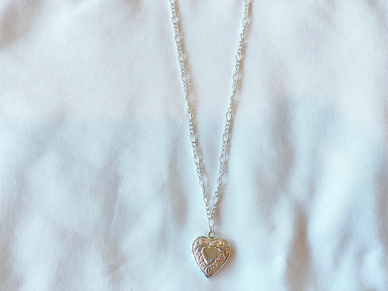 Peut inclure: Un collier avec un pendentif en forme de c&oelig;ur argent&eacute; et une cha&icirc;ne d&eacute;licate.