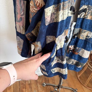 Puede incluir: Chaqueta patchwork azul marino con parches rectangulares y en forma de diamante. Los parches presentan varios patrones en beige, marr&oacute;n y rosa. La chaqueta tiene un bolsillo y cierres de palanca negros.