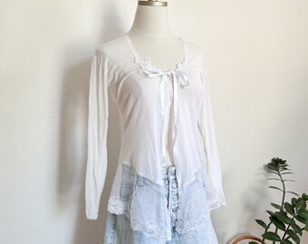 Blusa/cárdigan vintage blanca transparente de encaje con lazo y abertura frontal, ideal para el verano, estilo coqueto y delicado.