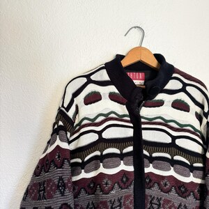 Peut inclure: Un cardigan zipp&eacute; &agrave; motif noir, blanc, marron et vert avec l'inscription "Brighton" sur l'&eacute;tiquette.