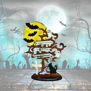May include: A Halloween-themed wooden sign with a full moon, bats, and ghosts. The sign directs to "Haunted Hayrides," "Trick or Treat," and "Spook Central." A black cat, a tombstone, and a ghost are also featured.