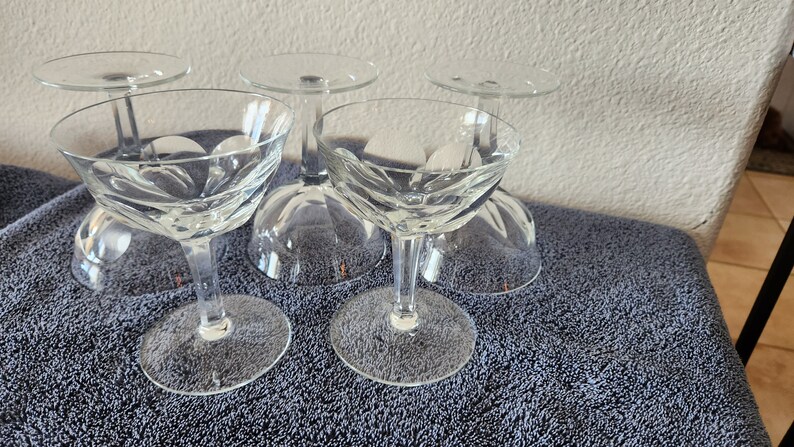 May include: Set of four clear glass stemmed cocktail glasses with a cut glass design.