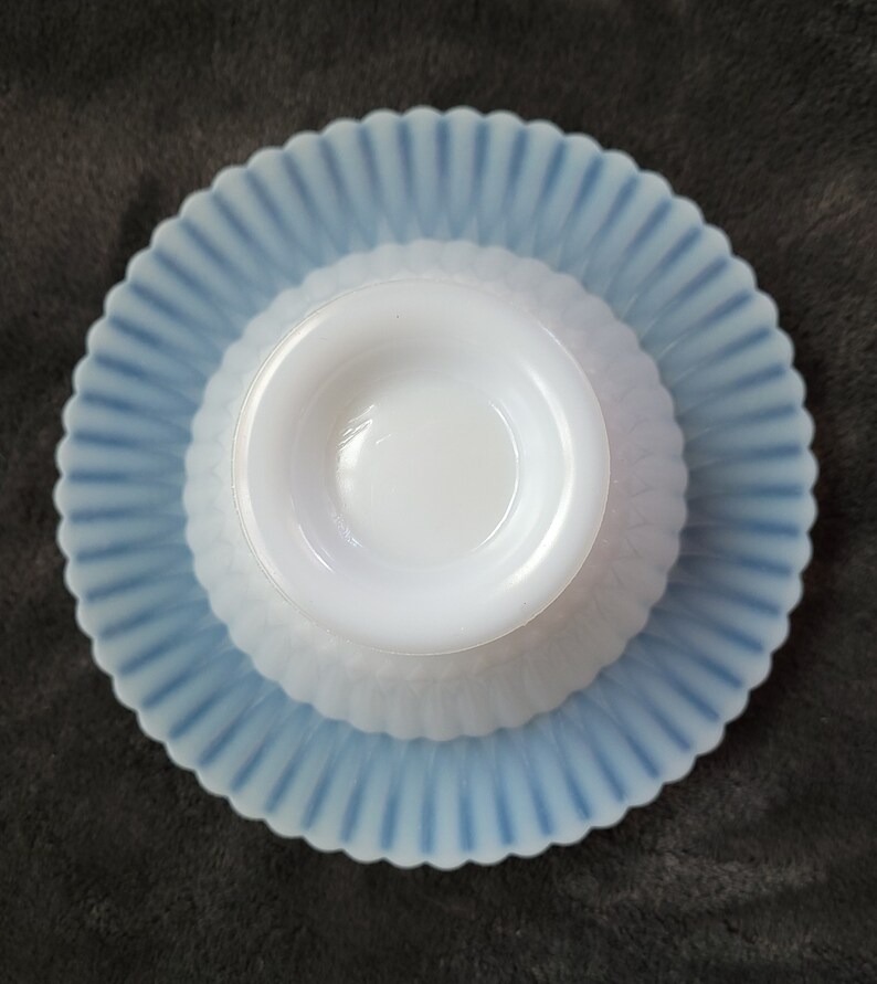 Pu&ograve; includere: Una ciotola in vetro di latte bianco con un bordo smerlato blu e bianco si trova su un piattino smerlato blu e bianco abbinato.
