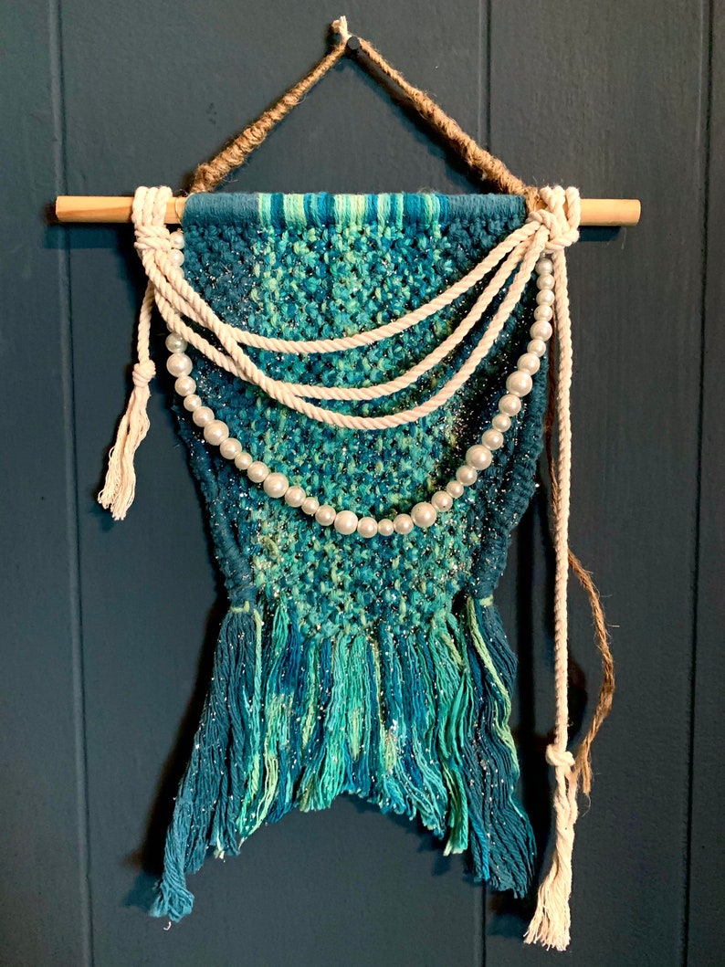 glitter and twine embellishments hanging from a wood dowel rod Handmade macrame mermaids tail wall hanging wfaux pearls