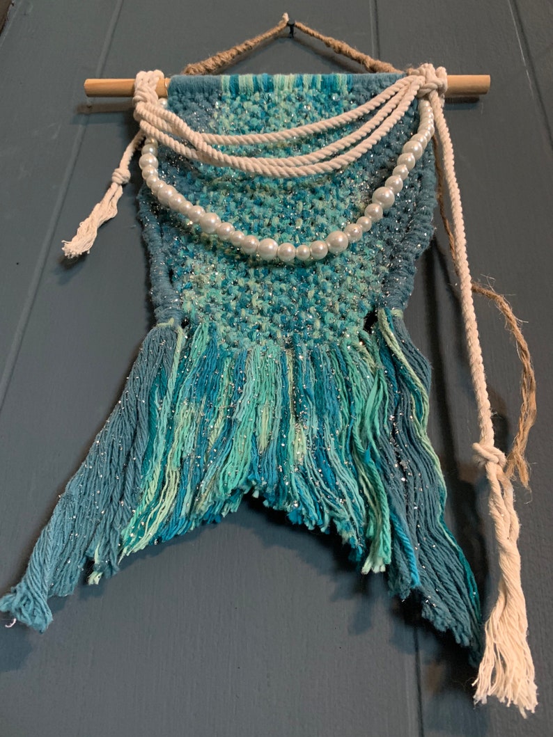 glitter and twine embellishments hanging from a wood dowel rod Handmade macrame mermaids tail wall hanging wfaux pearls