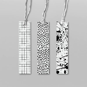 May include: Three black and white patterned bookmarks with string attached. The bookmarks feature a grid pattern, a polka dot pattern, and a splatter paint pattern.