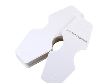 May include: A stack of white cardboard necklace display cards with a hole for hanging and a slot for the necklace. The cards have a rounded edge and a small hole at the top for hanging. The text "Your text/Logo Here" is printed on the card.