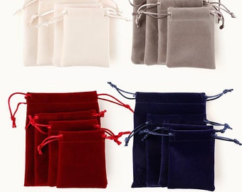 Pode incluir: Conjunto de 12 saquinhos de veludo com cordão de ajuste em quatro cores: marfim, cinza, vermelho e azul marinho. Os saquinhos estão dispostos em quatro pilhas de três, cada pilha apresenta uma cor diferente. Os saquinhos são feitos de veludo macio e luxuoso e têm um fecho de cordão.