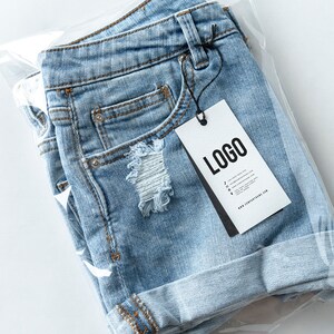 May include: Light blue denim shorts with a distressed detail and a white tag that says "LOGO" with a website address.