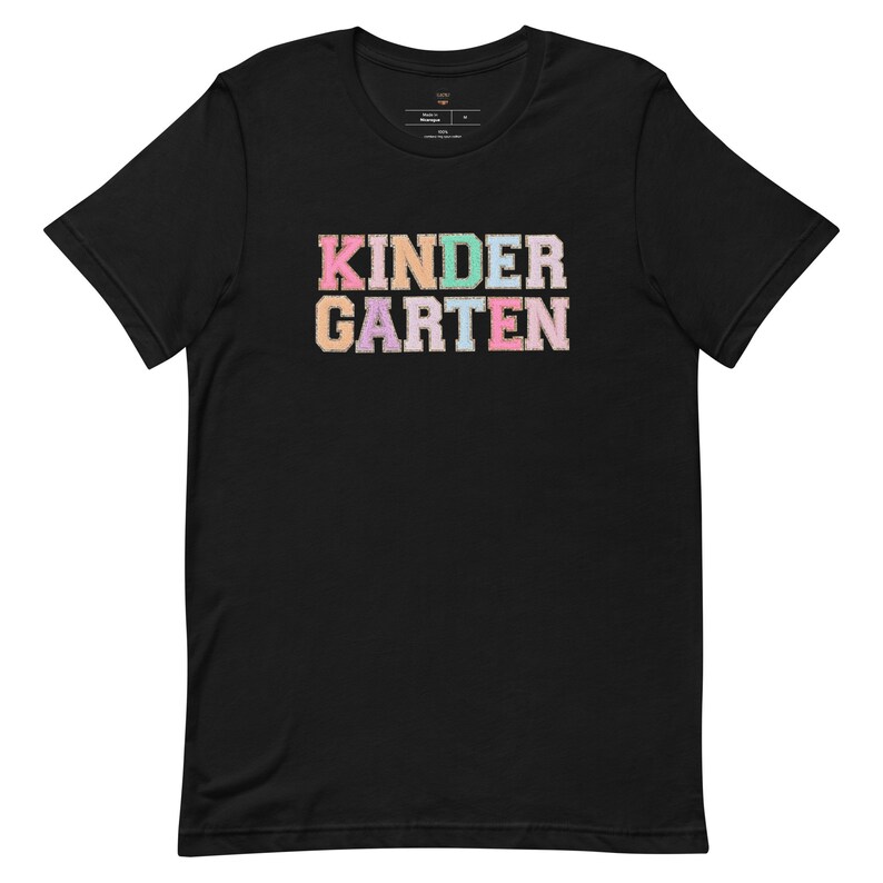 May include: Black t-shirt with the word "KINDERGARTEN" in colorful, glittery letters.