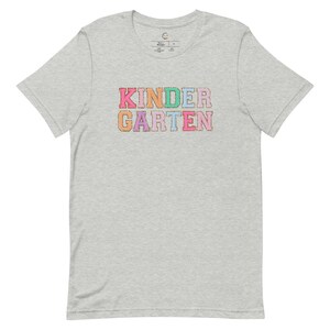 May include: A heather grey t-shirt with the word "KINDERGARTEN" printed in colorful letters.