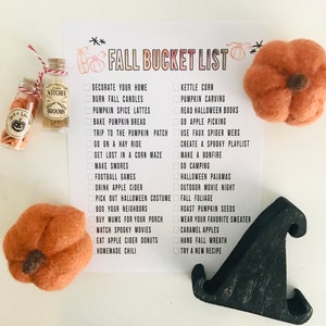 May include: A printable checklist with a white background and black text. The checklist is titled "Fall Bucket List" and includes activities such as "Decorate your home", "Burn fall candles", "Pumpkin carving", "Read Halloween books", "Go apple picking", "Use faux spider webs", "Create a spooky playlist", "Make a bonfire", "Go camping", "Halloween pajamas", "Outdoor movie night", "Fall foliage", "Roast pumpkin seeds", "Wear your favorite sweater", "Caramel apples", "Hang fall wreath", "Try a new recipe".