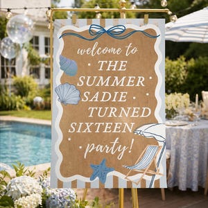 Puede incluir: Un letrero de bienvenida para una fiesta con temática de playa. El letrero marrón tiene detalles en azul y blanco, con ilustraciones de conchas marinas, una estrella de mar y una silla de playa. El texto dice "welcome to THE SUMMER SADIE TURNED SIXTEEN party!"