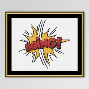 May include: A framed comic book style art piece with the word "BOING!" in red letters. The word is set against a yellow burst with black outlines, framed in gold and black.