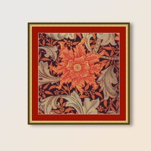 May include: A framed cross-stitch pattern featuring a large orange flower with intricate details, surrounded by smaller flowers and leaves in shades of green and brown.