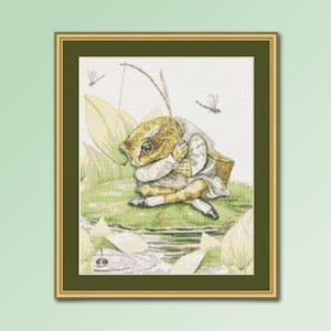 May include: A cross-stitch pattern of a frog wearing a vest and holding a fishing rod. The frog is sitting on a lily pad with dragonflies flying around it.