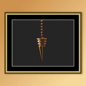 May include: A framed artwork showing a gold-coloured bottle stopper suspended against a dark background. The stopper has a conical shape with stacked, circular elements and a chain. The artwork is framed in a gold-coloured frame.