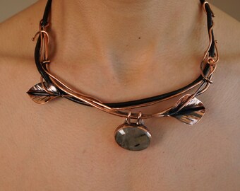 May include: A copper and leather necklace with a large, round, gray gemstone pendant and two copper leaf accents.