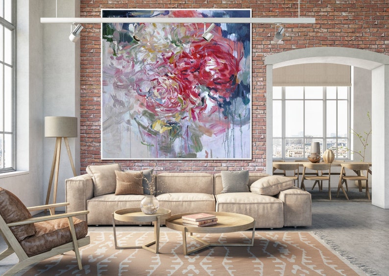 May include: Abstract painting of pink, red, and white flowers with a textured background. The painting is hanging on a brick wall in a living room setting.