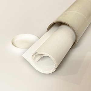 May include: A white canvas roll is partially unrolled and is being stored in a cardboard tube. The canvas is rolled up tightly and the tube is made of cardboard with a clear plastic covering.