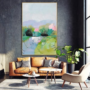 Puede incluir: Pintura abstracta de paisaje con tonos verdes, azules y rosas. La pintura representa un r&iacute;o que fluye a trav&eacute;s de un campo con &aacute;rboles y colinas en el fondo.
