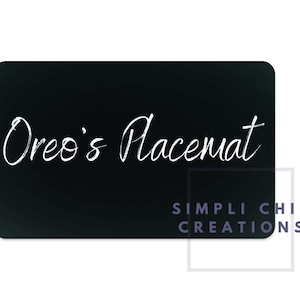 May include: Black chalkboard placemat with white text that reads "Oreo's Placemat" and the text "SIMPLI CHIC CREATIONS" in the bottom right corner.