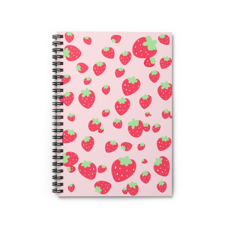 May include: A pink spiral notebook with a pattern of red strawberries on the cover.