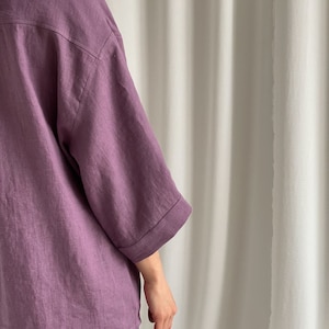 May include: A purple linen shirt and shorts set. The shirt has a relaxed fit and three-quarter sleeves. The shorts are a matching color and have a relaxed fit.