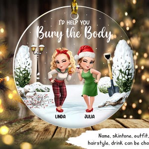 May include: A round Christmas ornament with the text "I'D HELP YOU Bury the Body." It features two cartoon women, one in a Santa hat and green dress, the other in a red bow and plaid pants. The names "Linda" and "Julia" are below the women.