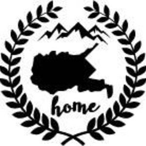 May include: Black and white graphic of a mountain range and a map outline, encircled by a laurel wreath. The word "home" is written in cursive below the map. The design is suitable for various applications.