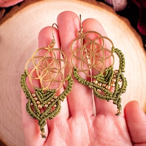May include: Gold earrings with a geometric design and green macrame fringe.
