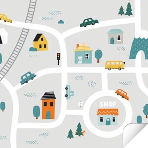 May include: A colorful illustration of a town with houses, cars, trees, and a shop with the word "SHOP" above it. The illustration is on a light gray background.