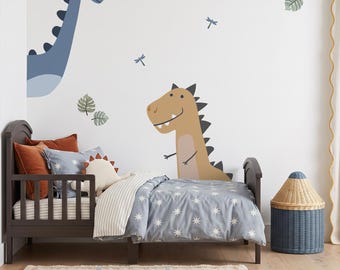 Puede incluir: Una cama infantil de madera marrón oscuro con un edredón de estrellas azules y blancas, una sábana a rayas y almohadas lisas. La pared tiene grandes vinilos decorativos de un dinosaurio azul de cuello largo, un T-Rex beige y hojas verdes.