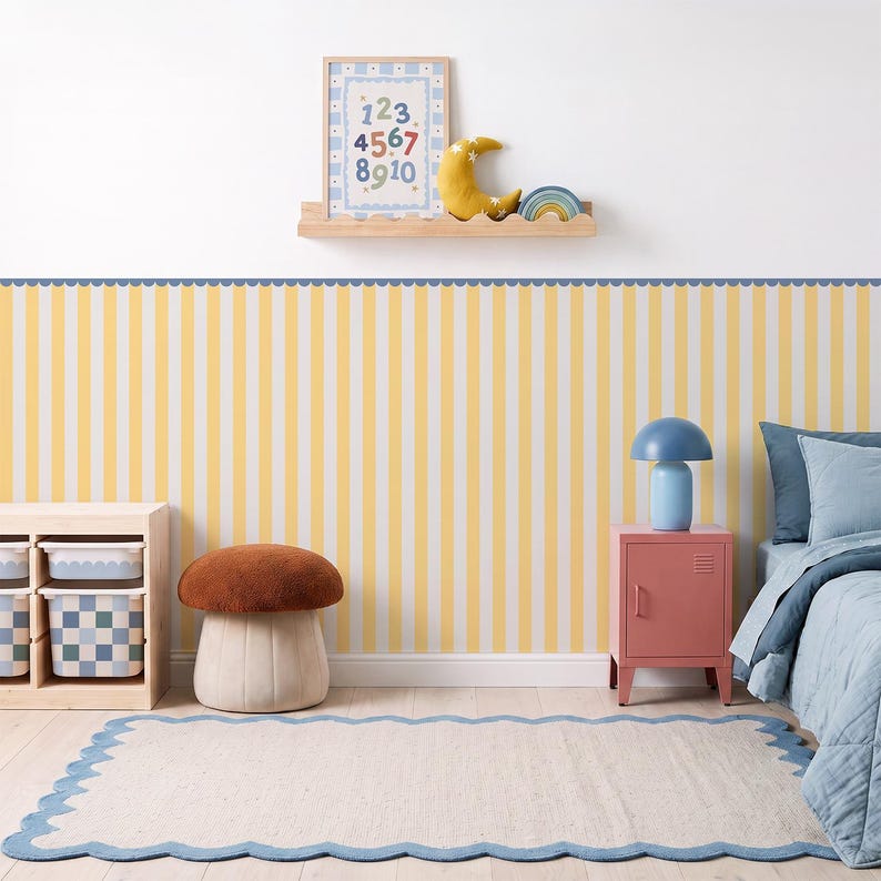 May include: Wallpaper featuring vertical yellow and white stripes with a blue scalloped border at the top. The design creates a clean, repetitive pattern suitable for wall decor, providing a bright and structured aesthetic for a room interior.