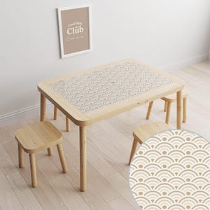 May include: A wooden table with a light brown tabletop featuring a geometric pattern of beige and brown arches. The table is surrounded by three wooden chairs.