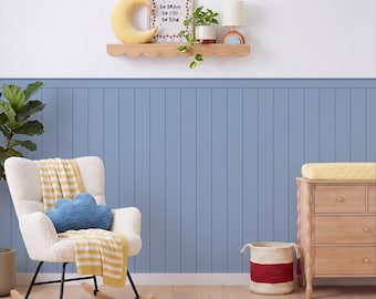 May include: A nursery room featuring a white rocking chair with a yellow striped blanket and a blue cloud pillow, a wooden dresser, a scalloped wall shelf with a moon pillow, a framed sign reading Be Brave Be Silly Be Kind, and a plant.