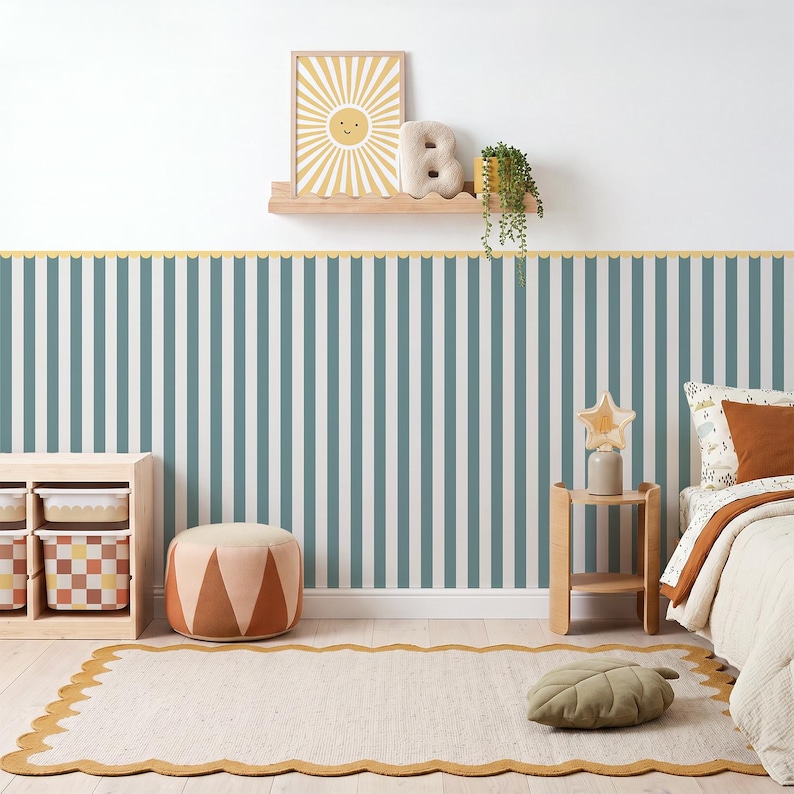 May include: Wallpaper featuring vertical stripes in muted blue and white, accented by a scalloped yellow border. The room includes a wooden shelf with a sun print, a letter B, a plant, a storage unit with patterned bins, and a scalloped rug.