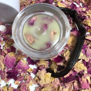 Pu&ograve; includere: Un barattolo di vetro trasparente con un coperchio bianco riempito di un balsamo verde chiaro. Il balsamo &egrave; decorato con petali di rosa rosa. Il barattolo &egrave; circondato da petali di rosa secchi e una bacca di vaniglia nera.