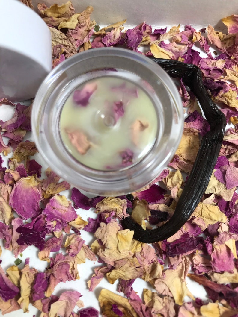 Pu&ograve; includere: Un barattolo di vetro trasparente con un coperchio bianco riempito di un balsamo verde chiaro. Il balsamo &egrave; decorato con petali di rosa rosa. Il barattolo &egrave; circondato da petali di rosa secchi e una bacca di vaniglia nera.