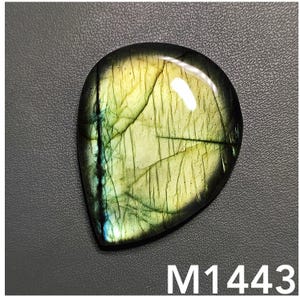 以下が含まれることがあります： 涙の形をした緑と黄色のラブラドライトの宝石のカボション。石は独特の虹色の輝きがあり、磨かれた滑らかな仕上げでセットされています。M1443.