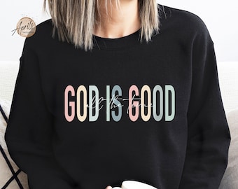 May include: A black sweatshirt with the text "GOD IS GOOD" in rainbow colors. The text is in a modern font style.